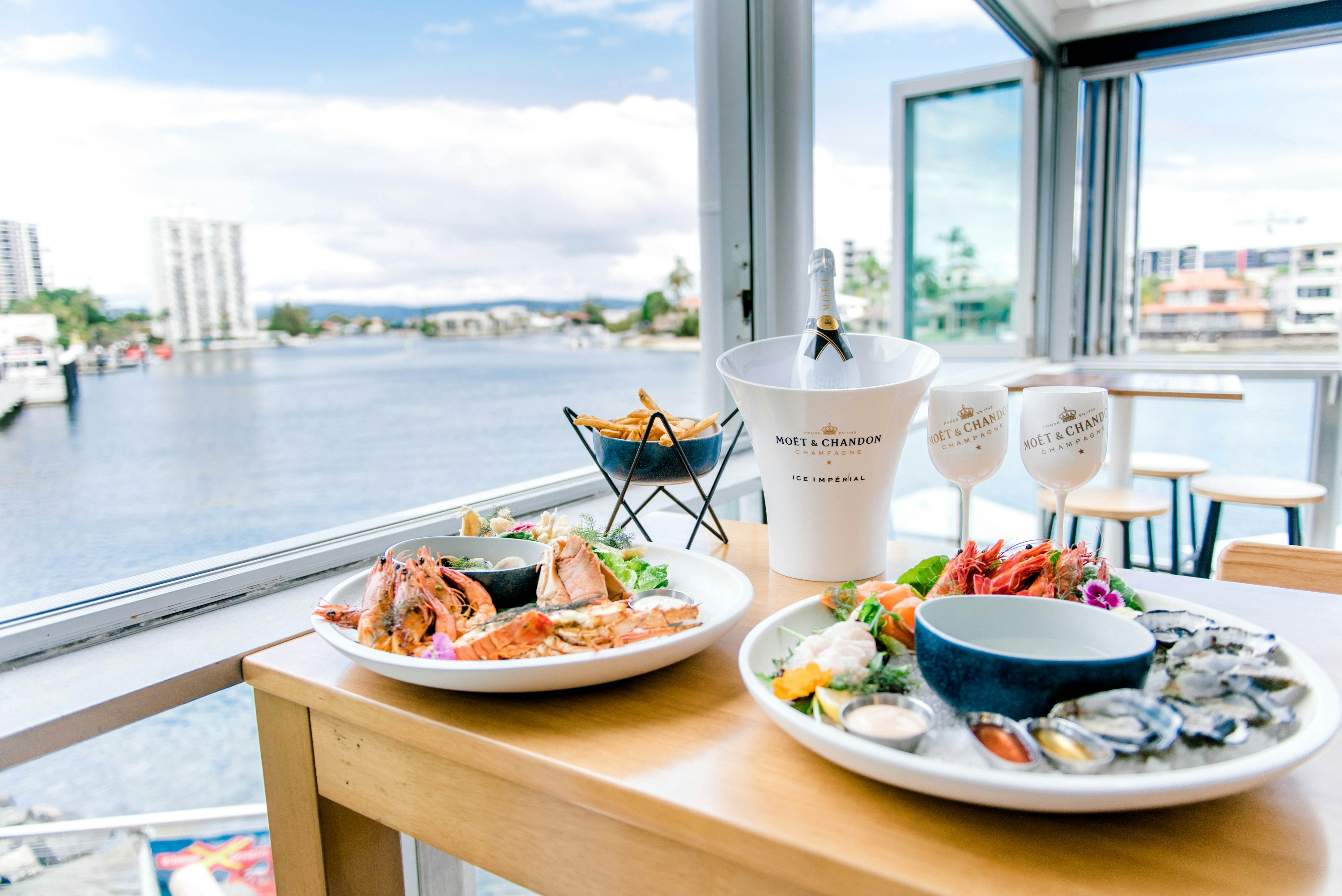 champagne and seafood on a table with waterfront views